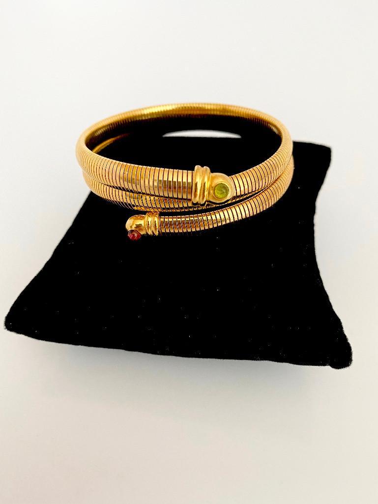 AN AMAZING 80'S NEIMAN MARCUS SNAKE BRACELET TOURMALINE: A never worn unsigned bracelet purchased in the mid 80's at neiman marcus. Heavy gold plated snake bypass with genuine pink and green cabochons of tourmaline. Will fit any size wrist.