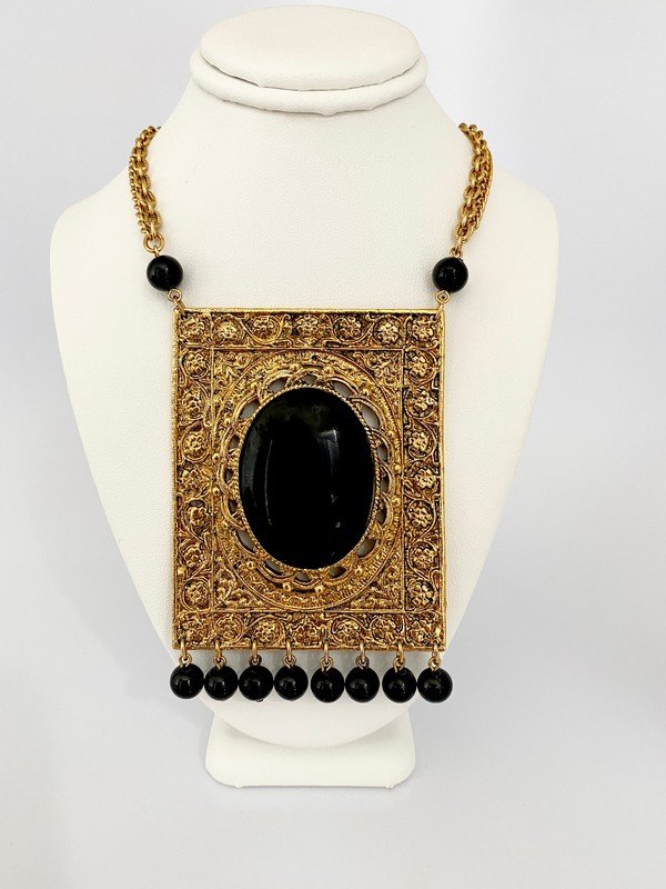 VINTAGE 70'S OVERSIZED ONYX ETRUSCAN RUNWAY NECKLACE: A 22" clasped necklace with a 3 1/2" drop onyx pendant with high karat plating with etruscan design