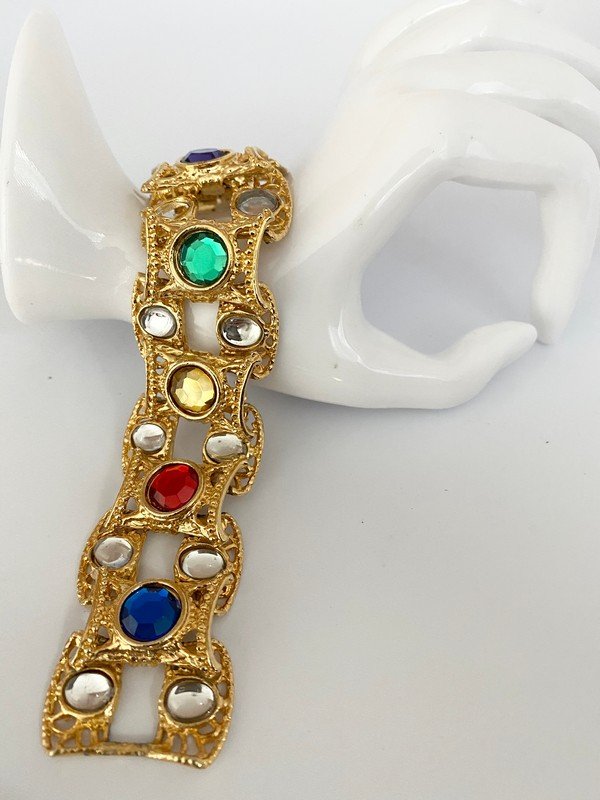 A VINTAGE FAUX JEWELED RUNWAY OVERSIZED 80'S BRACELET: A vintage jeweled runway bracelet with faux crystals in an ornate setting. The bracelet measures 8"