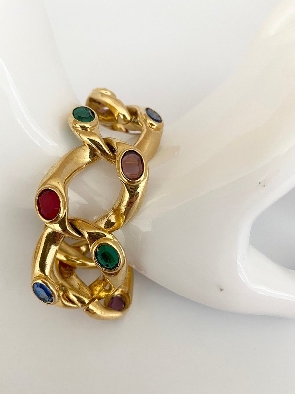 VINTAGE DESIGNER BEZEL SET 80'S FAUX JEWELED BRACELET: A 7 1.2" heavy goldtone bracelet with bezel set ruby, emerald, sapphire, and amethyst stones