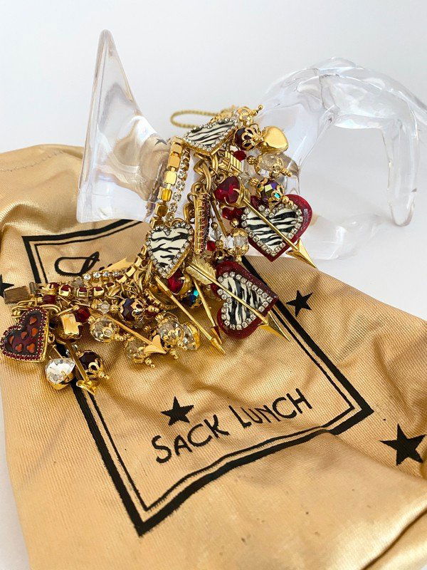 RARE LUNCH AT THE RITZ SACK LUNCH HEART CHARM BRACELET: An impossible to find Lunch at the Ritz charm bracelt with hundreds of charms over 7" long. The piece is exceptional and most likely a one of a kind and comes with the original silk Lunch at the Ritz