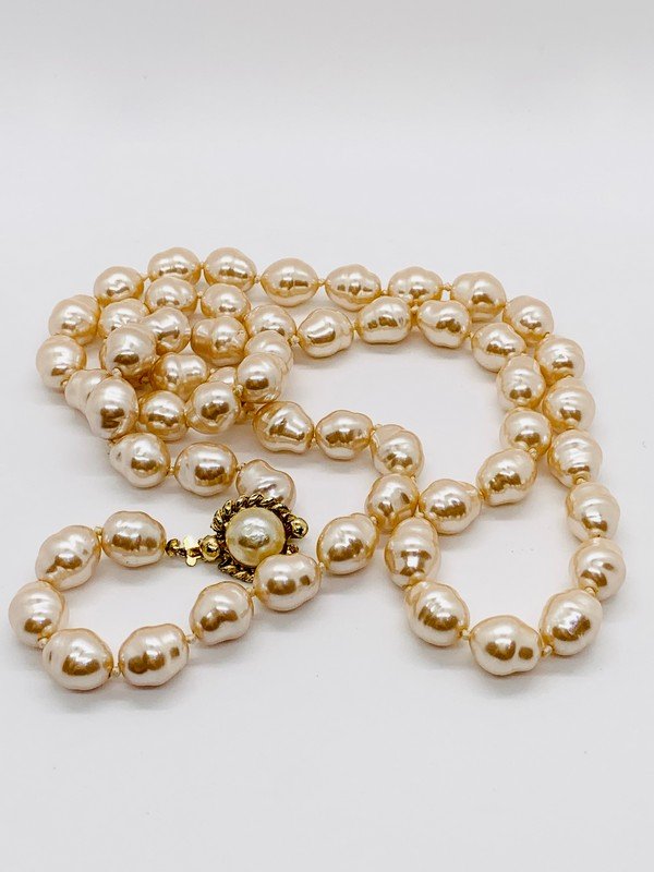 AN ICONIC STRAND OF CHANEL 1981 PARIS GRIPOIX PEARL SAUTOIR NECKLACE: A signed Chanel Made in France gripoix faux pearl clasped necklace hand knotted on silk. Measures 38"