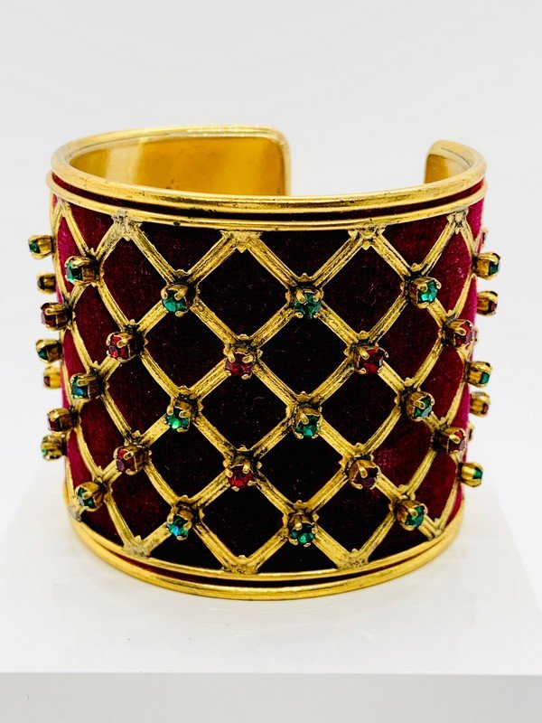 VINTAGE YVES ST LAURENT YSL RARE HAUTE COUTURE VELVET & CRYSTAL RUNWAY CUFF BRACELET: A signed vintage yves st laurent signed YSL rare crushed velvet in wine with prong set crystals in ruby and emerald caged in goldtone metal. The bracelet measures 2 1/2" tall