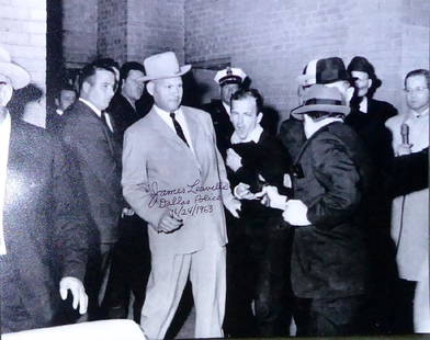 JFK: Dallas Policeman JAMES LEAVELLE - Photo Signed: JFK Assassination: James Leavelle (1920- ) Police Officer. Leavelle was escorting Lee Harvey Oswald through the basement of Dallas Police headquarters when Oswald was shot by Jack Ruby. 14” x 11