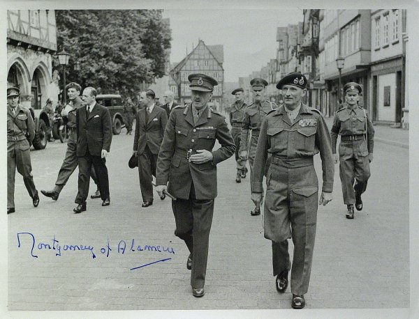 Field Marshall BERNARD MONTGOMERY - Photo Signed: Bernard L. Montgomery. 7 ½" x 5 ½" black and white photograph with an Imperial War Museum backstamp depicting Montgomery with other soldiers, signed "Montgomery of Alamein.
