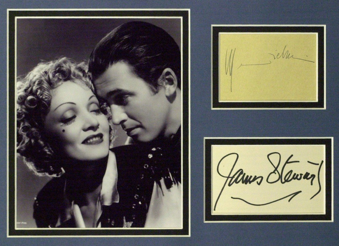 JAMES STEWART & MARLENE DIETRICH - Matted: James Stewart and Marlene Dietrich (1901-1992) German actress. . 4" x 2 ½" and 3 ½" x 2 ¼" signatures, double matted with a black and white photograph of the pair to 14" x 11".