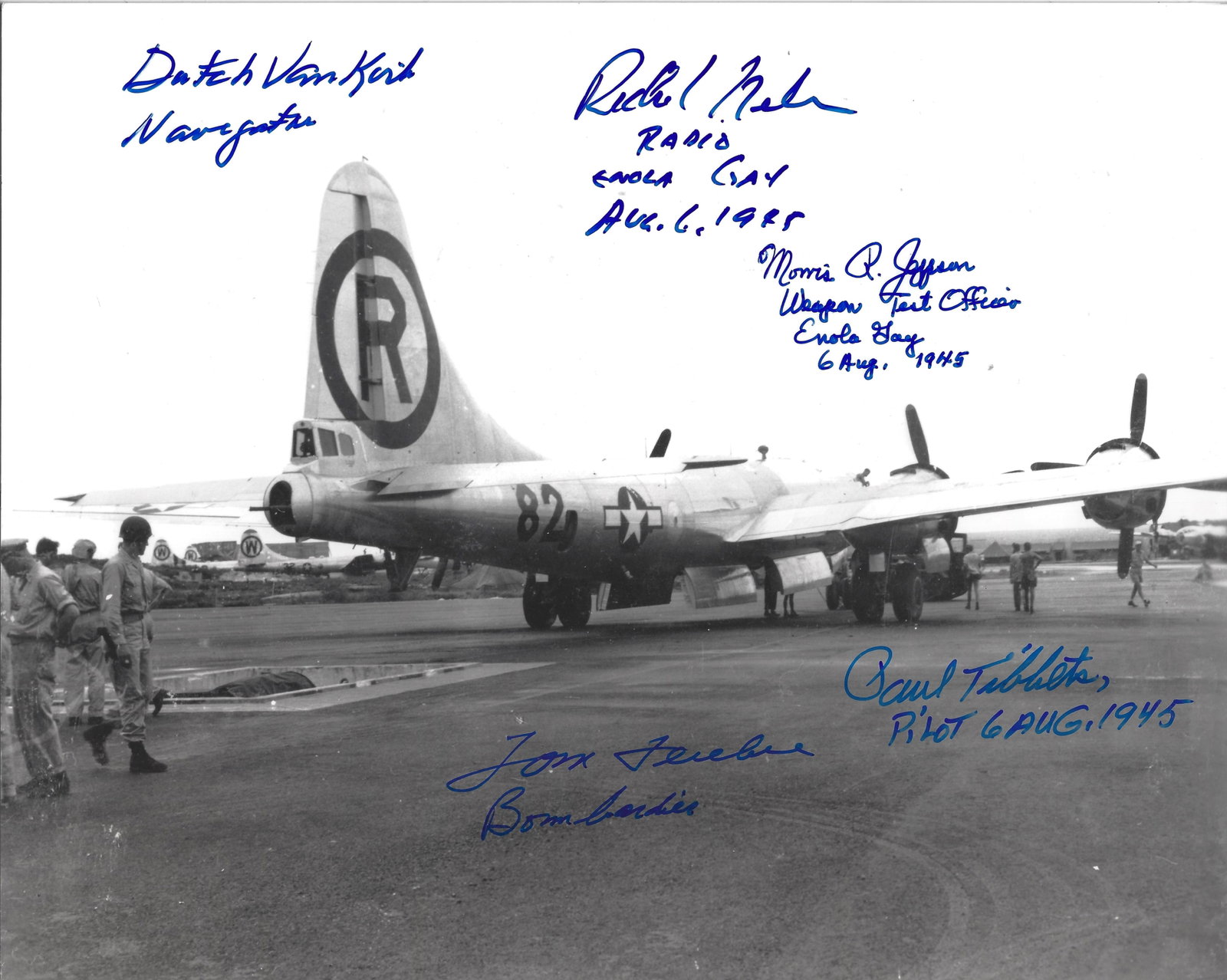 Dramatic Photo Enola Gay Backing Up Over Bomb Pit Signed by (5): Enola Gay 8"x10" black and white photograph of the B29 "Enola Gay" being backed over the bomb loading pit on Tinian by a Cletrac Tractor operated by the ground crew while Scientists and MP's look on A