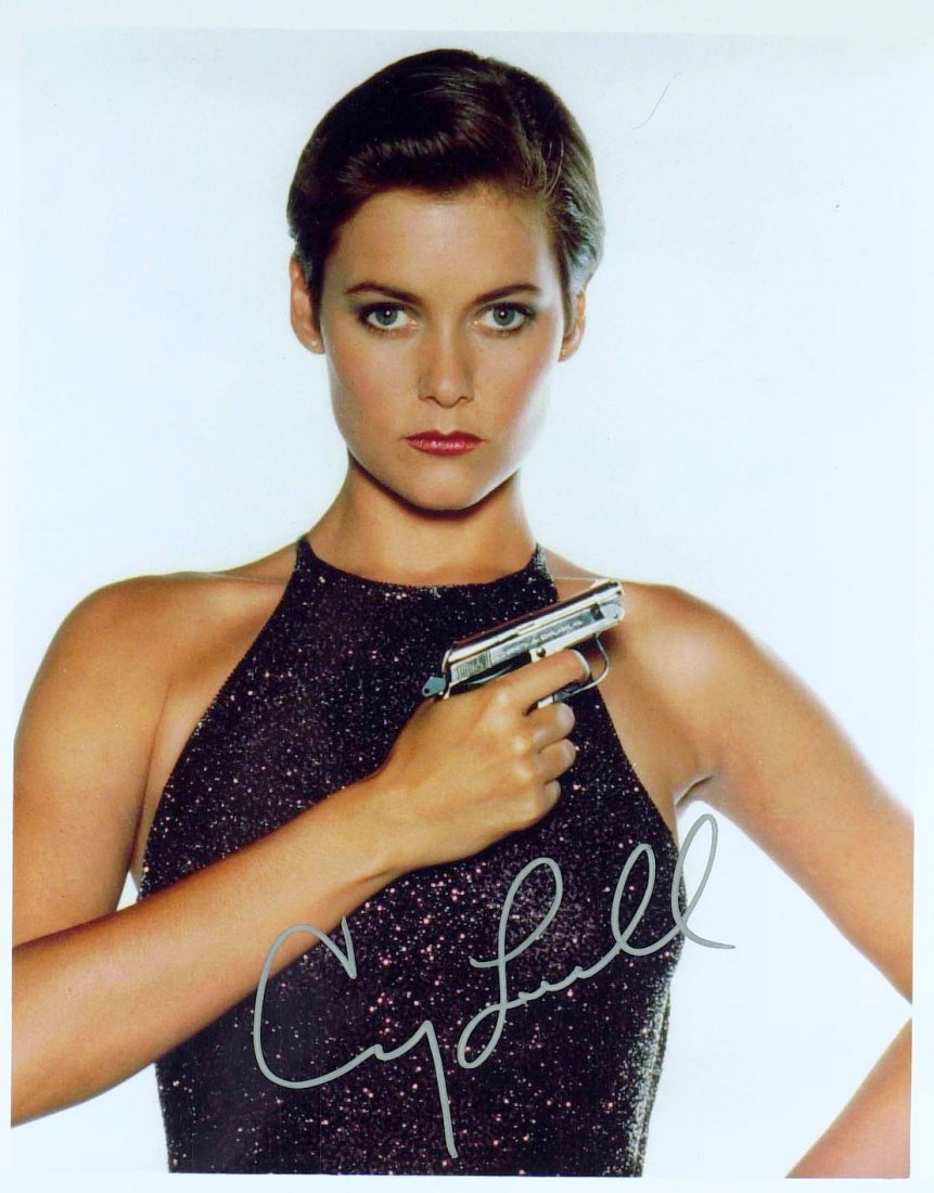 Bond Girl, Actress CARY LOWELL - Photo Signed: James Bond: Cary Lowell (1961- ) Actress. Lowell portrayed Pam Bouvier: an ex-Army pilot and CIA informant in the 1989 James Bond film, Licence to Kill. 8” x 10” color photograph, as Bouvier, sign
