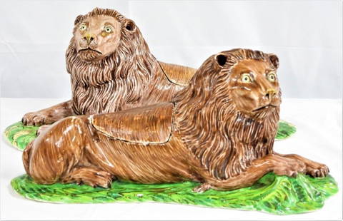 TWO LIONS IN SOFT CHANTILLY PORCELAIN OF THE EIGHTEENTH CENTURY, AND TWO FAIENCE LIDS: TWO LIONS IN SOFT PORCELAIN OF CHANTILLY OF THE XVIIIe SIECLE, AND TWO LIDS IN FAIENCE CIRCA 1740, MARKS IN BROWN WITH HUNTING HORN Represented lying on a curved oval base, the first looking on the le