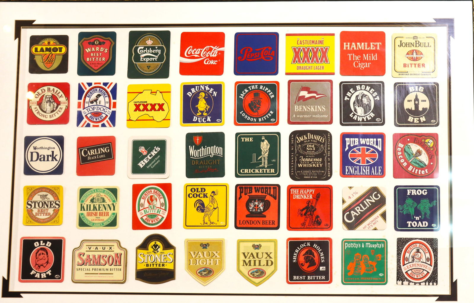 Framed Vintage collection of vintage British pub beer mats or coasters: Framed Vintage collection of vintage British pub beer mats or coasters A framed collection of vintage British pub beer mats, also known as beer coasters, is shown in the image. Many of the coasters ar