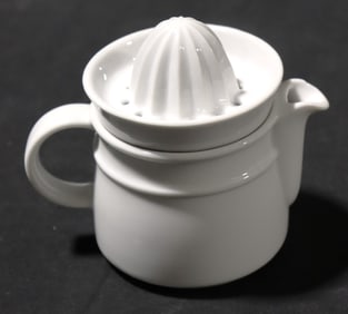 White porcelain citrus juicer with a built-in pitcher.
