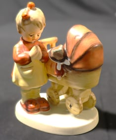 This is a Goebel Hummel "Doll Mother" figurine, also known as "Puppenmütterchen"
