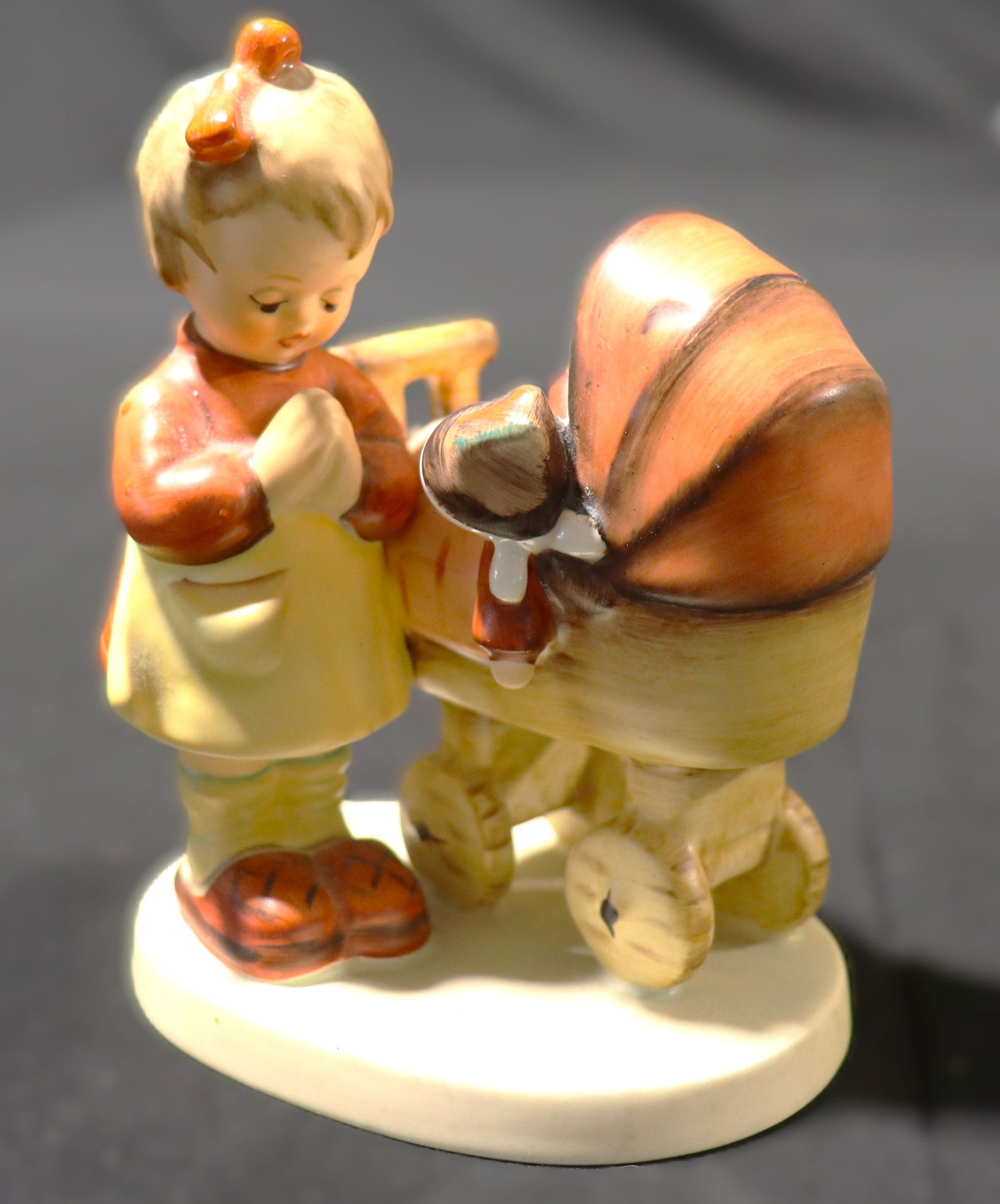 This is a Goebel Hummel "Doll Mother" figurine, also known as "Puppenmütterchen": This is a Goebel Hummel "Doll Mother" figurine, also known as "Puppenmütterchen" This figurine is a Goebel M.I. Hummel "Doll Mother" (German: Puppenmütterchen),