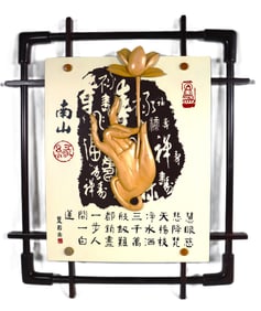 Framed Buddhist art featuring a carved hand in a mudra (symbolic gesture)