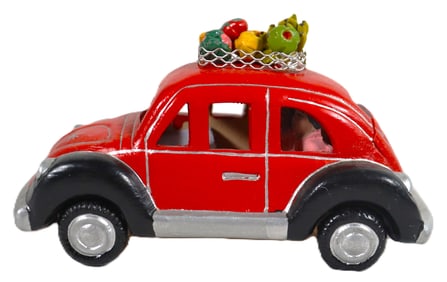 Vintage-style red car, a classic Volkswagen Beetle, featuring a rack on top filled with fruits or
