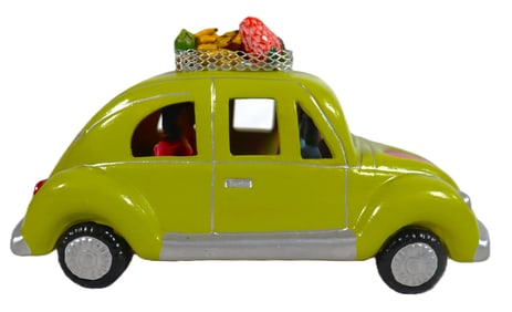 Vintage-style green car, a classic Volkswagen Beetle, featuring a rack on top filled with fruits or