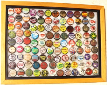 Framed collection is a display of vintage soda bottle caps.