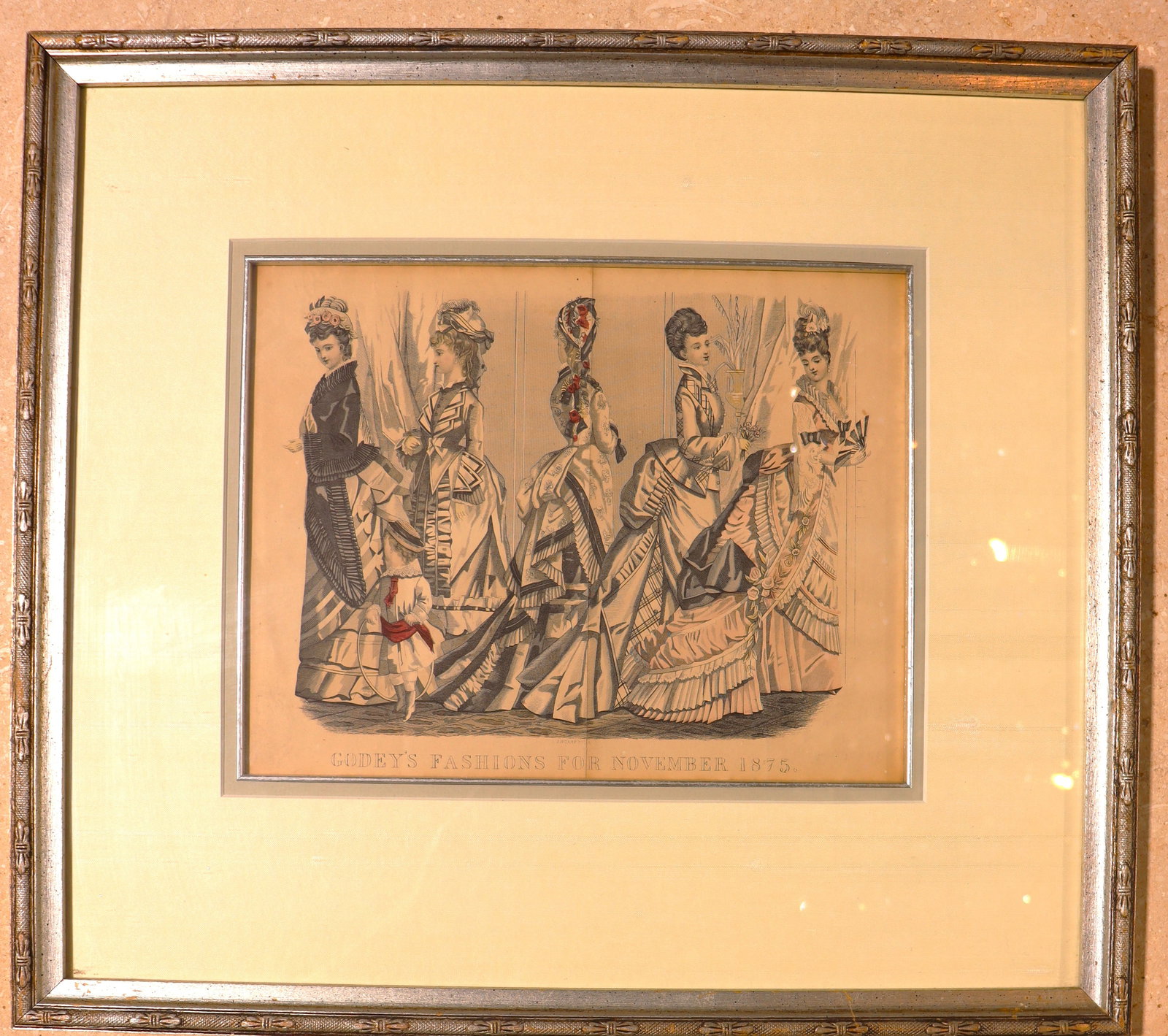 Framed print of Godey's Fashions for November 1875, an antique Victorian-era fashion plate.: Framed print of Godey's Fashions for November 1875, an antique Victorian-era fashion plate. It features five women and a young girl in fashionable attire for the era, specifically