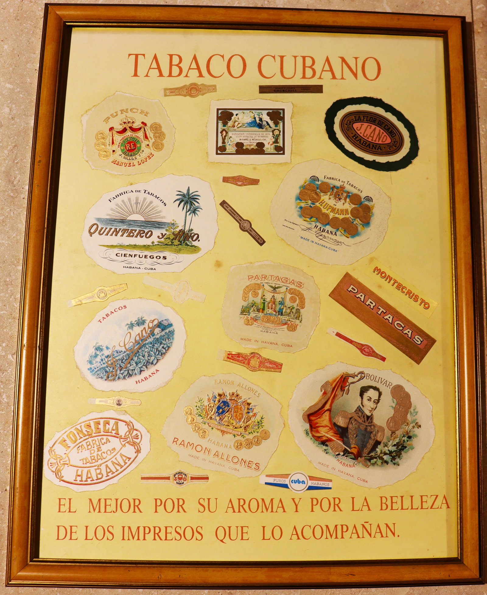 Framed vintage Cuban cigars label: Framed vintage Cuban cigars label, likely dating from the 1950s or 1960s. A collage cigar labels and bands from various brands, along with text advertising the tobacco., titled "TABACO