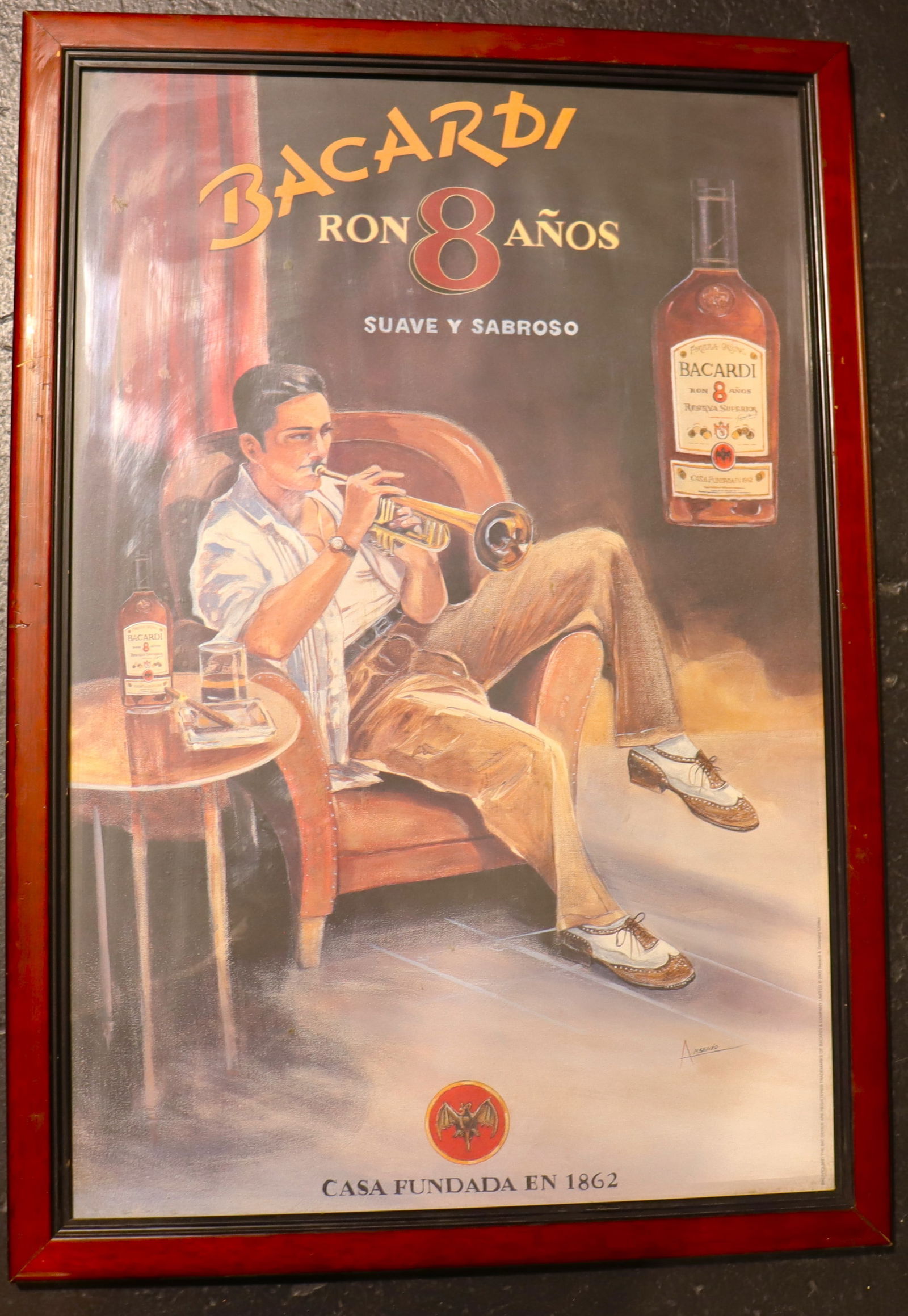 Framed Vintage Advertising Poster for Bacardi Ron 8 Años: Framed Vintage Advertising Poster for Bacardi Ron 8 AnosThis image shows a vintage-style advertising poster for Bacardi Ron 8 Años. The artwork has a vintage Cuban feel, with a man in a chair