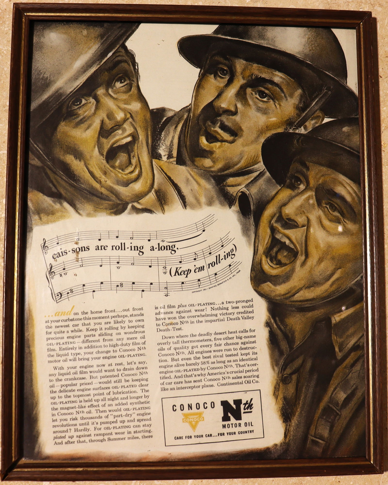 Framed Vintage Advertising for Conoco N motor oil, likely from the World War II era: Framed Vintage Advertising for Conoco N motor oil, likely from the World War II era A vintage advertisement for Conoco N motor oil, likely from the World War II era. The ad features three