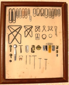 Framed Vintage collection of paper clips and other fasteners