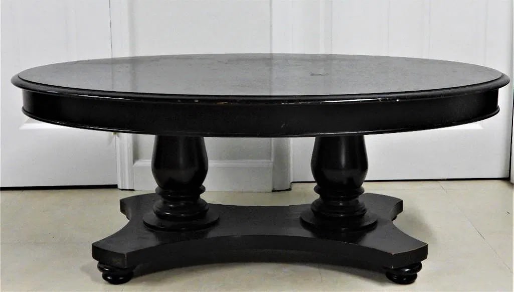 Vintage wooden coffee table featuring a oval top and a sturdy base with two ornate pedestals. (1 of 3)