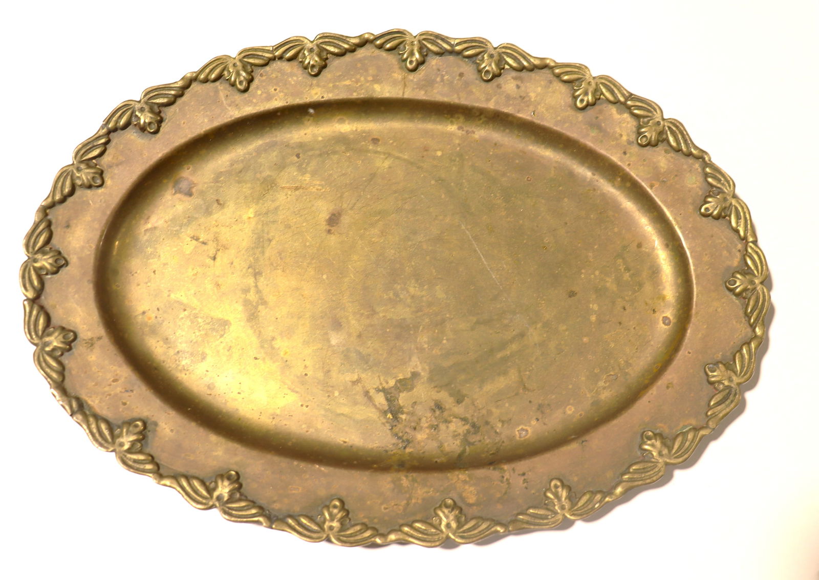 vintage-style, oval brass tray features a decorative floral border and is typically used for (1 of 2)