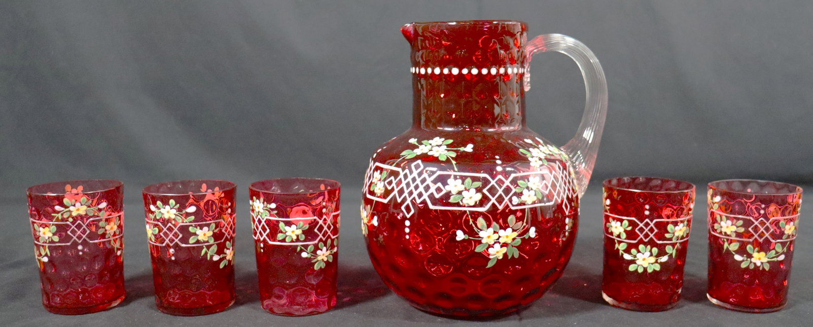 VINTAGE RUBY RED GLASS PITCHER AND FIVE GLASSES DECORATED WITH FLOWERS.: VINTAGE RUBY RED GLASS PITCHER AND FIVE GLASSES DECORATED WITH FLOWERS. DIMENSIONS GLASS: Height 3.75 inch / 9,5 cm 