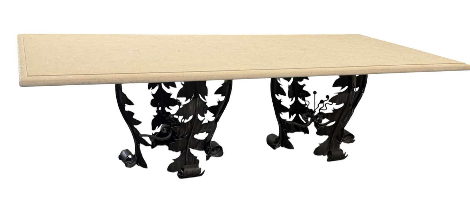 LARGE Wrought Iron & Travertine Slab Dining Table: This elegant Dining Table features a rectangular travertine top resting on two highly decorative wrought iron bases. The bases are intricately crafted with a botanical motif, showcasing stylized