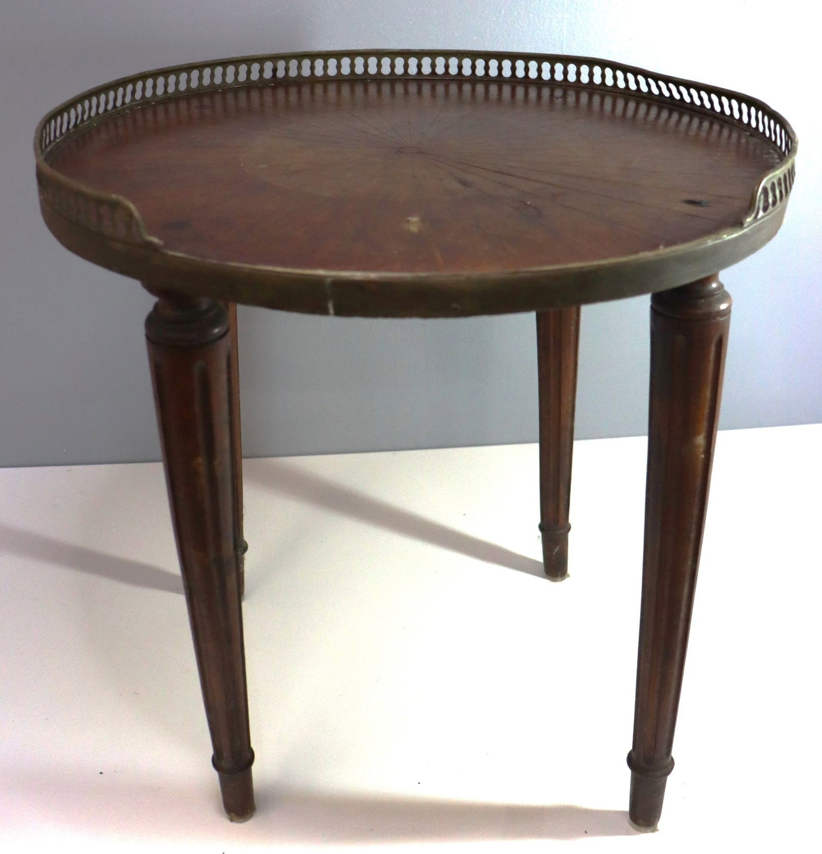 Antique French Neoclassical Style Brass Gallery R: This exquisite antique side table features a classic Neoclassical design, characterized by its elegant form and refined details. The round tabletop is crafted from wood with a rich, dark finish and is