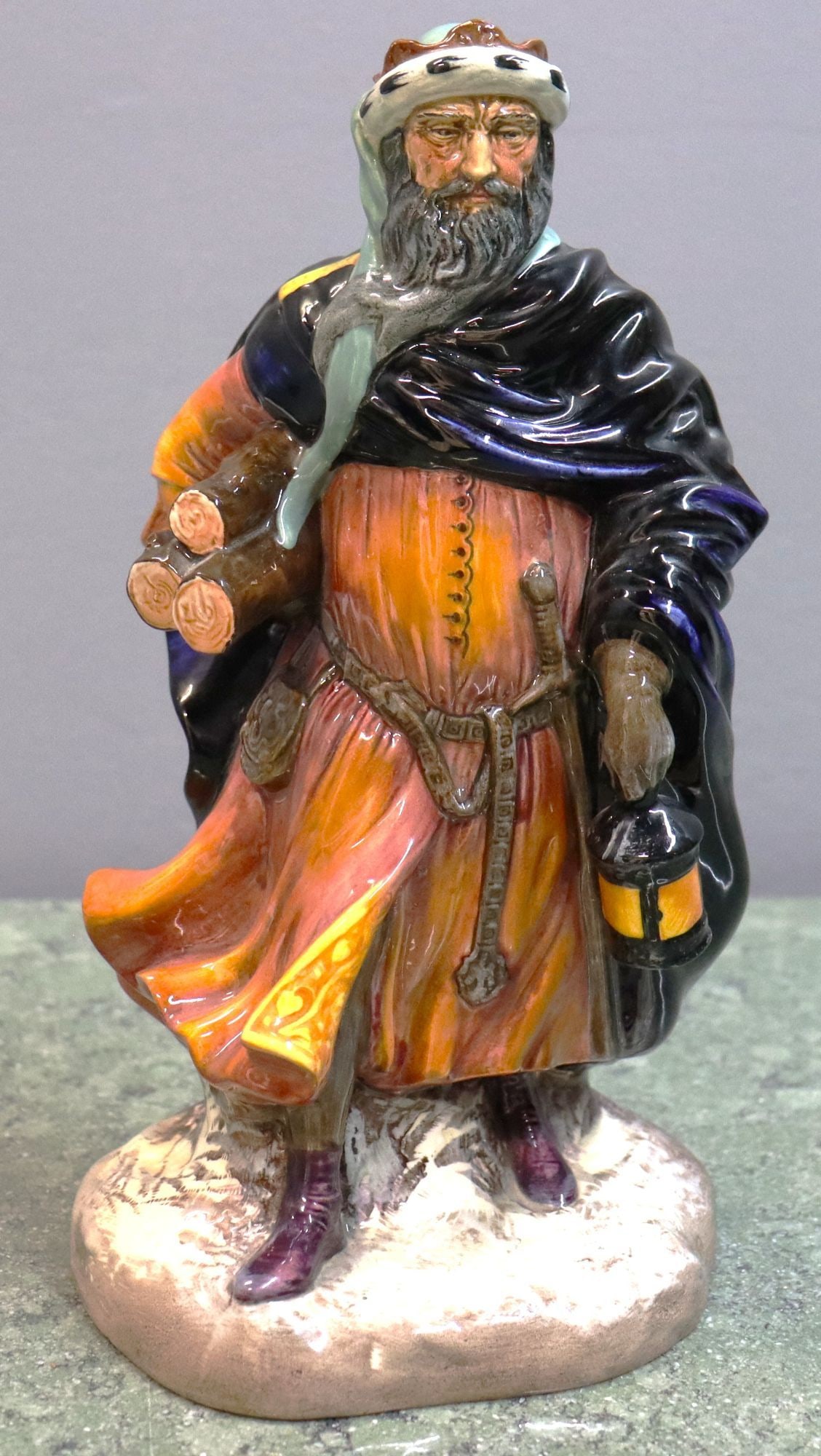 Royal Doulton "Good King Wenceslas" HN 2118 Figur: This is a Royal Doulton porcelain figurine titled "Good King Wenceslas," model number HN 2118. The figure depicts a regal man with a beard, wearing a cloak and a tunic in shades of orange, black, and 
