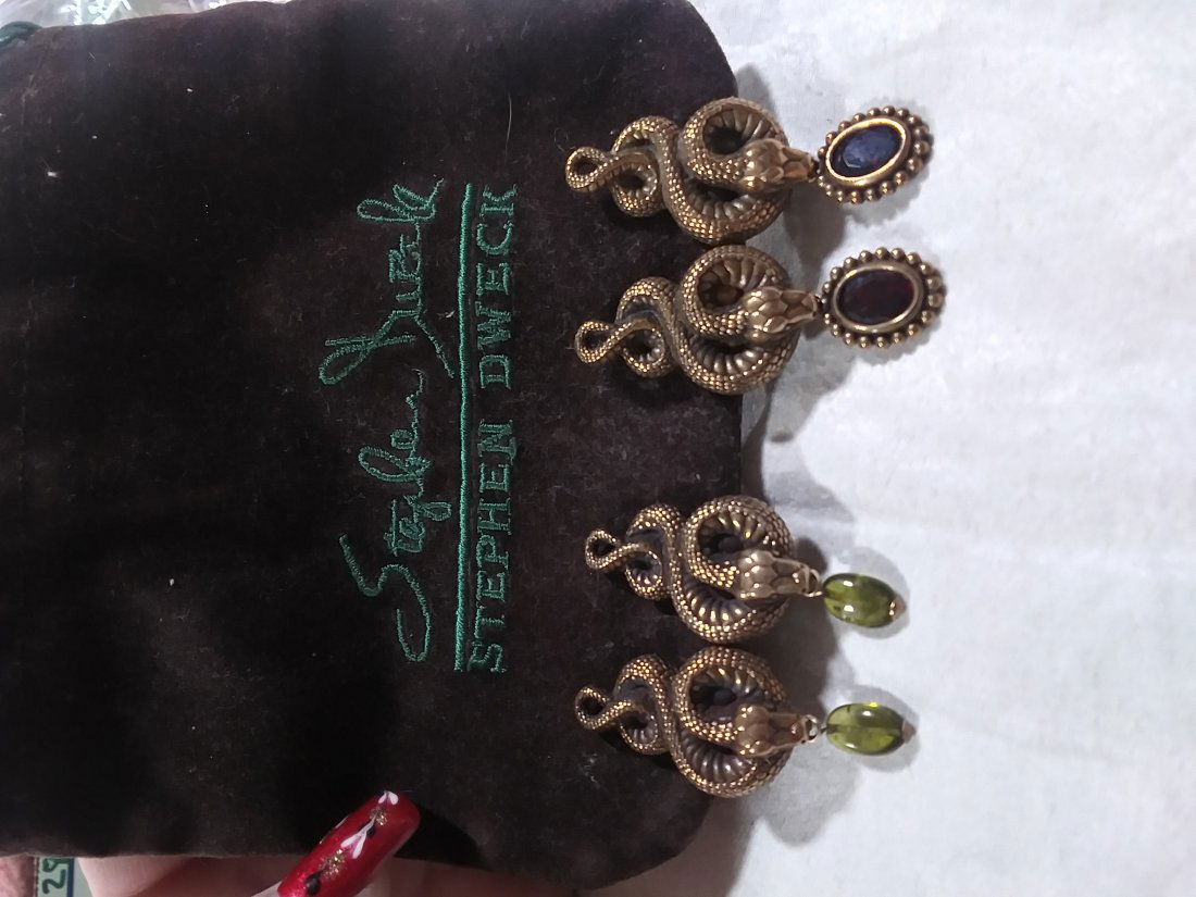 2 pairs Stephen Dweck Sterling Snake earrings: 2 pairs Stephen Dweck Sterling Snake earrings. .925 Sterling silver . One pair has garnet colored stones while the other pair has green stones that dangle from the snakes mouths. Stamped sterling silv
