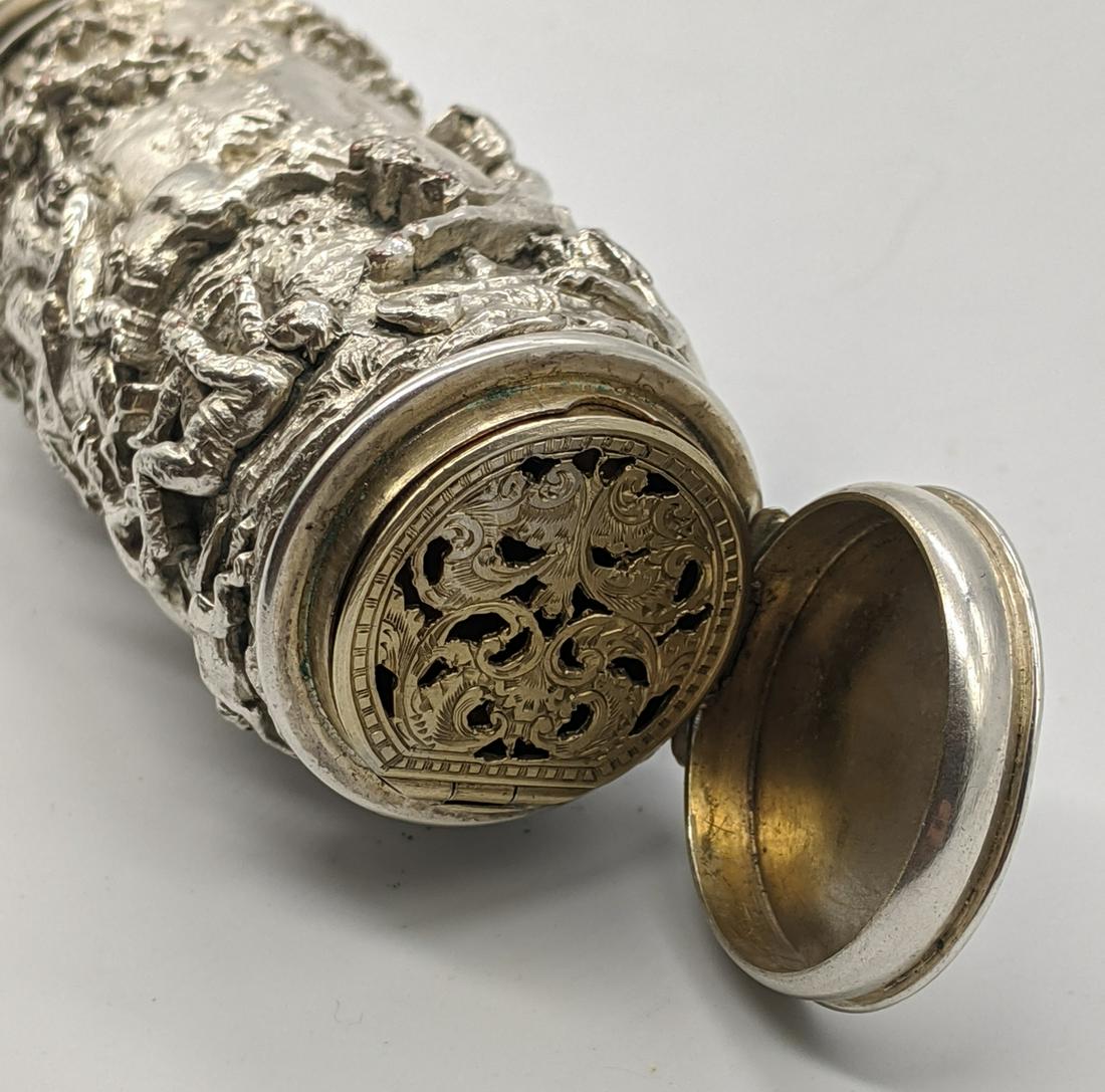 A silver vinaigrette/scent bottle with huntings scenes: A silver vinaigrette/scent bottle with huntings scenes to side, integrated gilt compartment with fretwork cover to one end, the top having release opening mechanism H.8cm