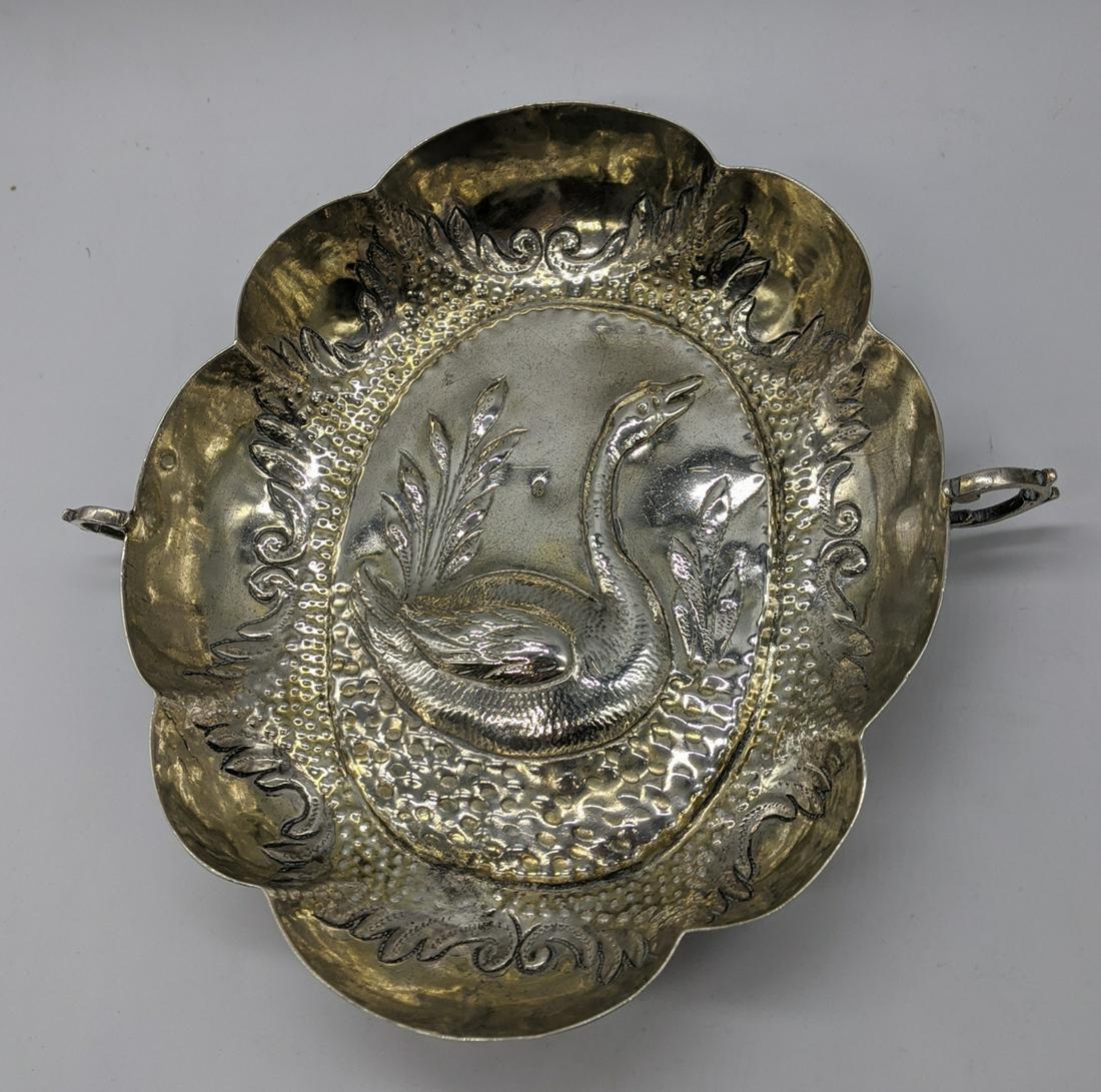 A German/Austrian silver twin handled dish depicting a: A German/Austrian silver twin handled dish depicting a Swan, repousse embossed, 173g, H.3.5cm L.18cm W.19cm