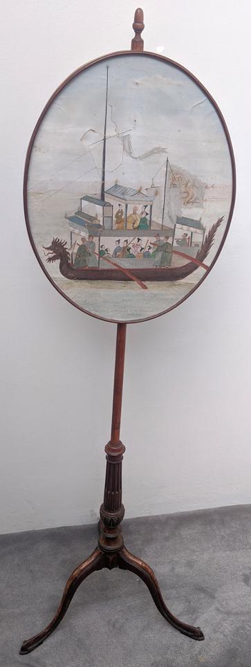 A 19th century Chinese style mahogany pole screen,: A 19th century Chinese style mahogany pole screen, acorn finial, the leather parchment oval painted with a Chinese dragon boat, fluted and carved stem with tripod base with painted floral designs (A/F