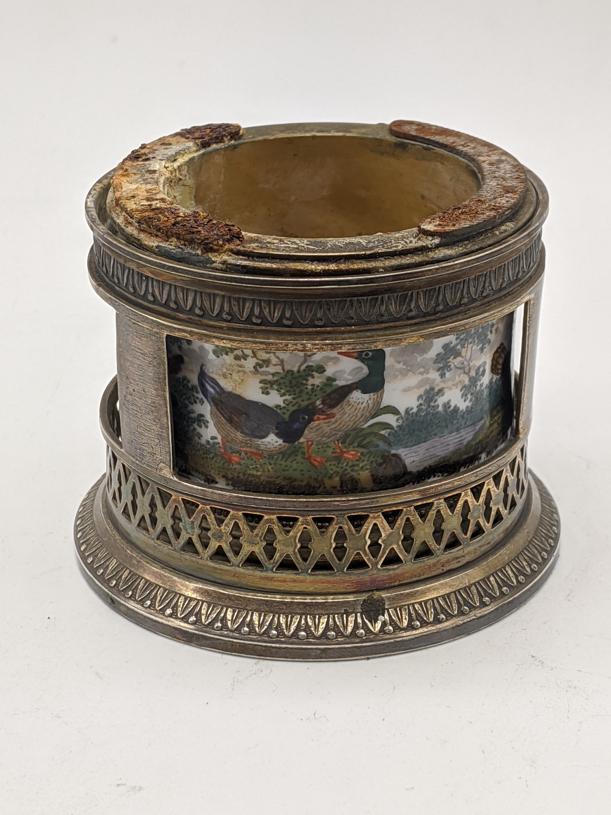 A Gustave Keller silver match striker holder, internal: A Gustave Keller silver match striker holder, internal porcelain liner painted with scenes of animals, late 19th century, French hallmarks, H.5cm D.6cm