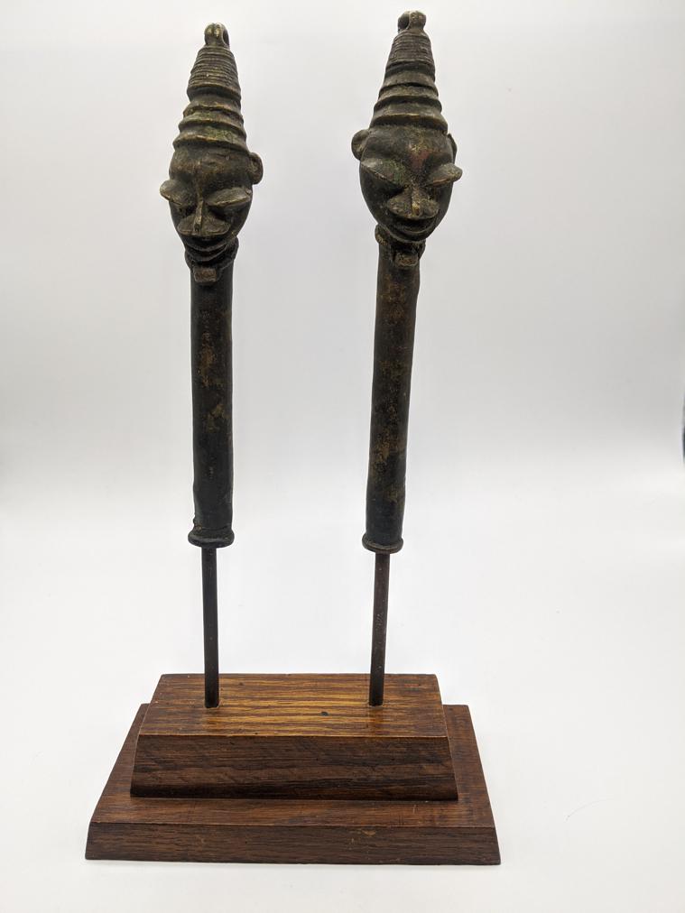 A pair of Nigerian tribal art Ogboni Society Edan: A pair of Nigerian tribal art Ogboni Society Edan Pendants, Yoruba People, Nigeria, raised on wooden base, H.24cm (not including base)