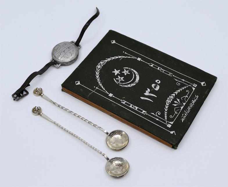 A pair of Islamic silver coin spoons together with a: A pair of Islamic silver coin spoons together with a white metal bracelet and book. Islamic Interest (3)