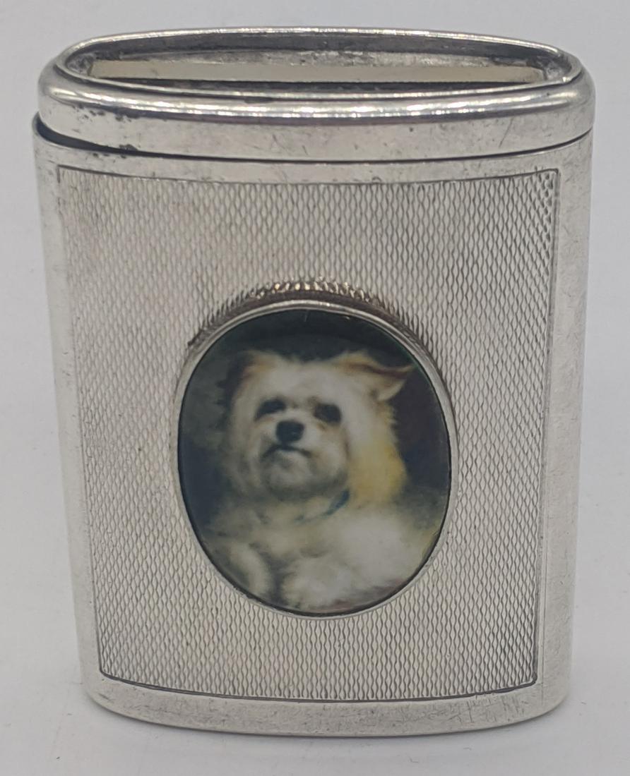 A silver vesta case mounted with enamel portrait of a: A silver vesta case mounted with enamel portrait of a Terrier dog, engine turned to front and back, hallmarked Birmingham, 1925, maker Atkins Bros, H.6cm W.4.5cm