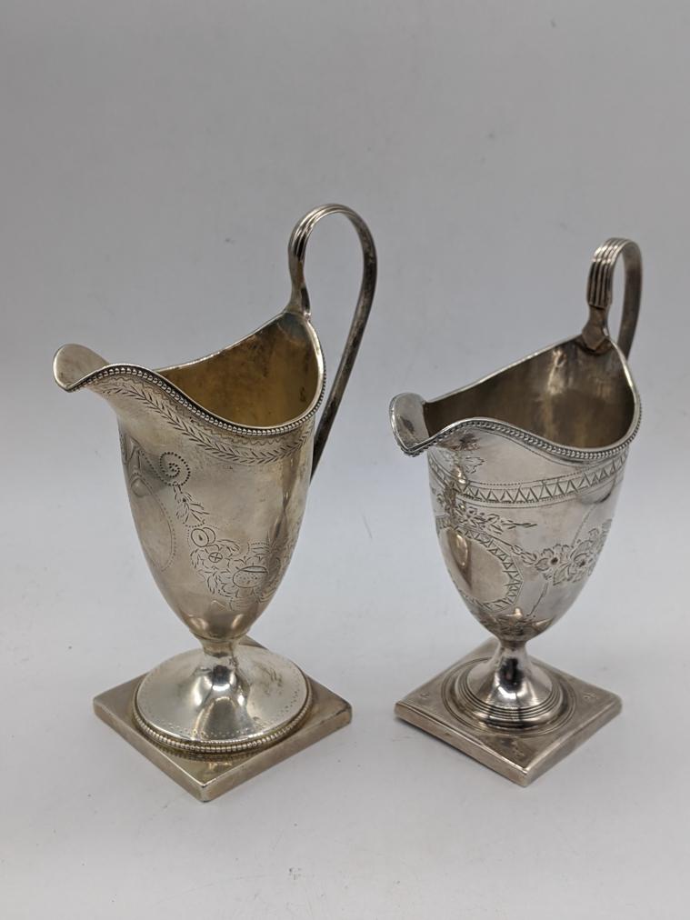 A George III silver cream jug, etched decor, vacant: A George III silver cream jug, etched decor, vacant cartouche, hallmarked London, 1783, maker SH, H.17cm, together with another George III silver cream jug, etched decor, vacant cartouche, hallmarked 