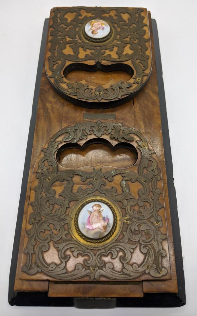 A Victorian walnut veneered extending book shelf by: A Victorian walnut veneered extending book shelf by Field Late Stocken of 67 Regents Street, the ends with applied brass and circular porcelain plaques depicting cherubs