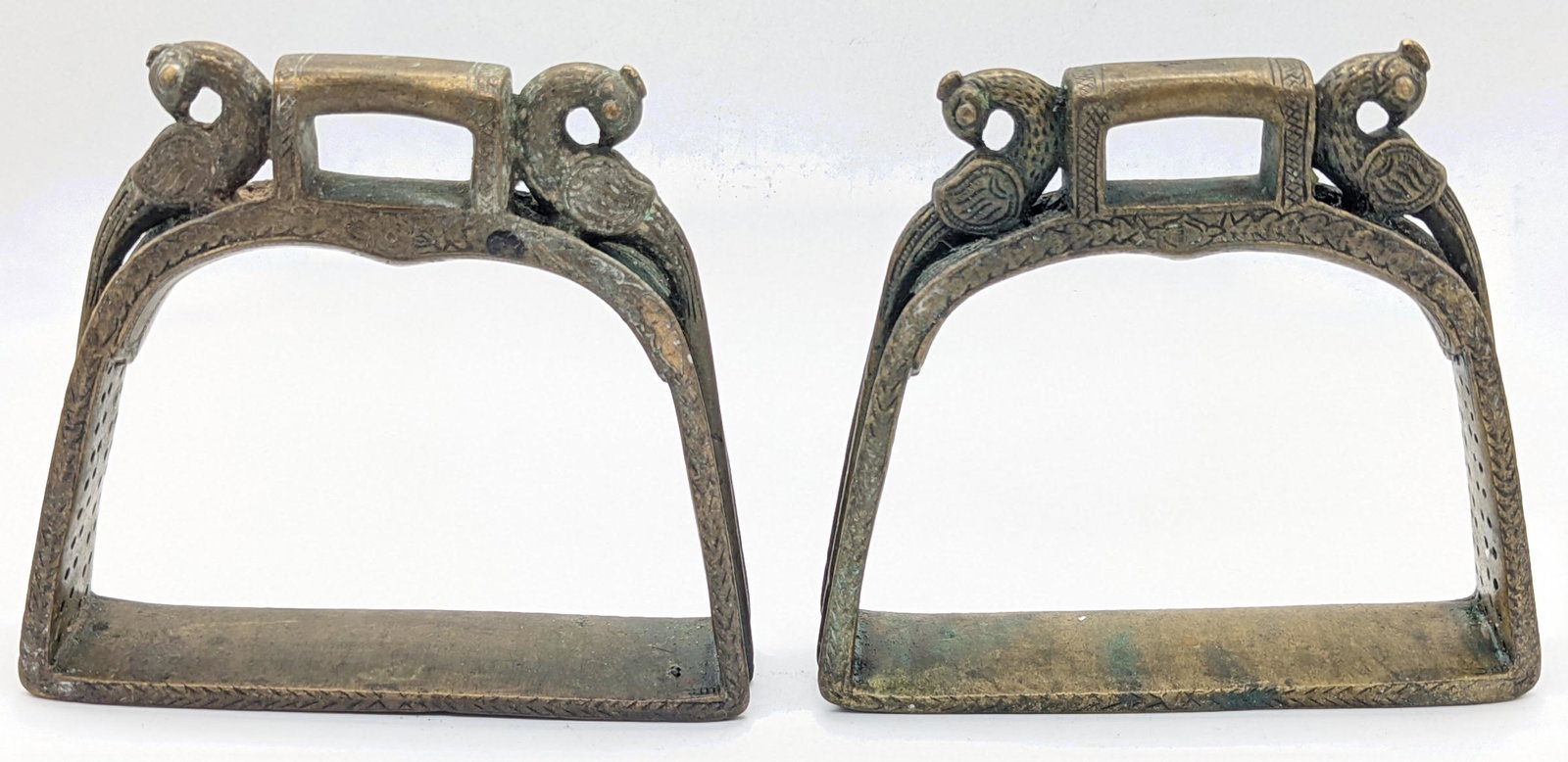 A pair of 18th century Deccani Indian open worked brass horse stirrups with peacock finials, H.11cm (1 of 2)