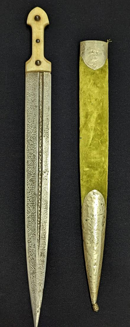 A 19th century Caucasian dagger (Kindjal), quranic engraved scripture to blade, horn and bone hilt,: A 19th century Caucasian dagger (Kindjal), quranic engraved scripture to blade, horn and bone hilt, green velvet scabbard with silver mounts with etched floral motifs, total length 62cm, blade length