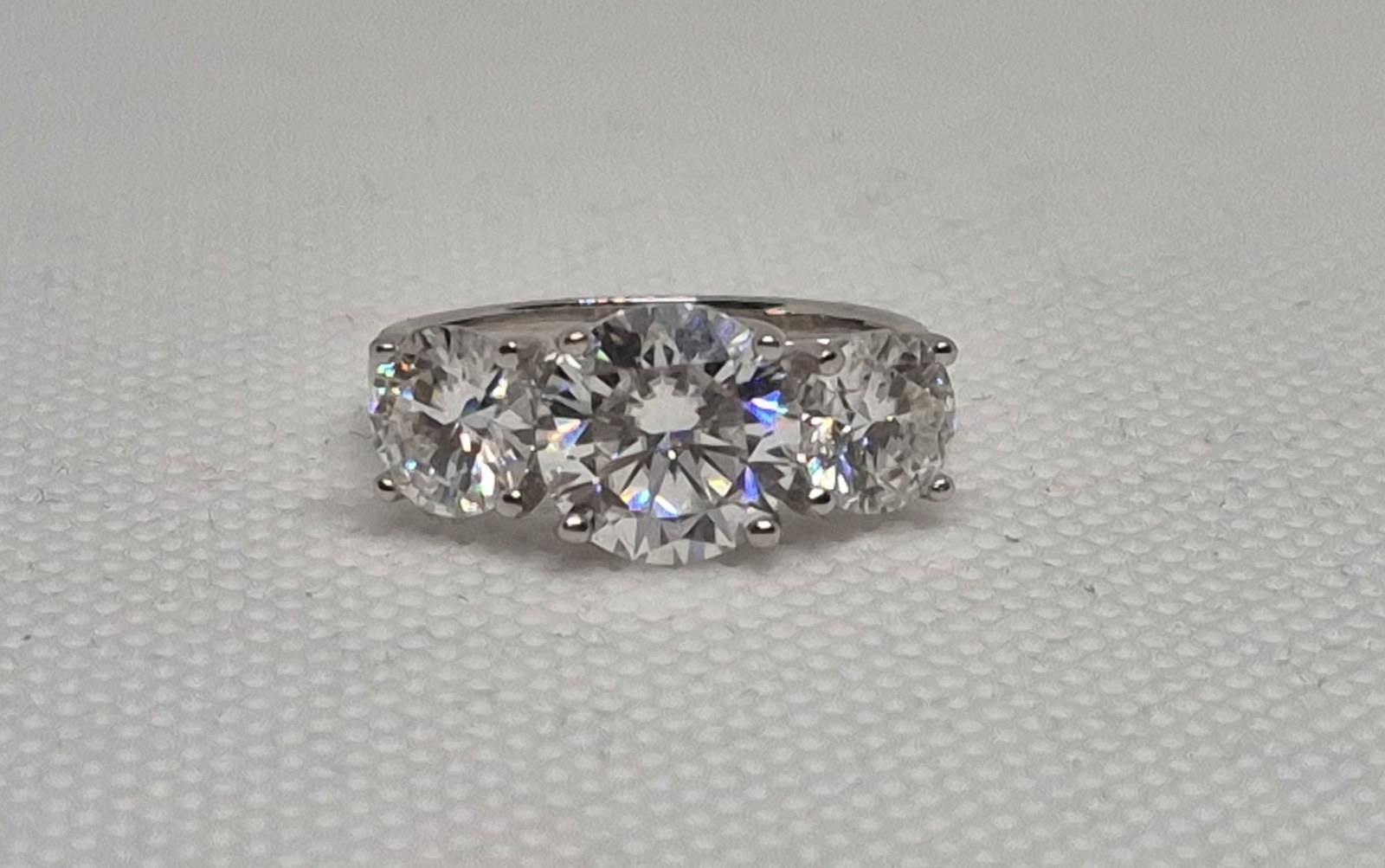 5.0 Carat Infinity Sterling Silver Moissanite Ring GRA REPORT: 5.0 Carat Infinity 18k Gold Plated Moissanite Ring1 x 3 Carat Round Cut Moissanite2 x 1 Carat Round Cut MoissaniteAll = VVS1 / D925 Sterling Silver under Gold PlatingAll major stones come with GRA Cer