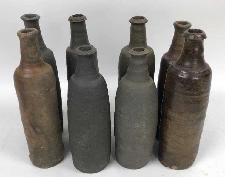 Group of 8 French ceramic wine bottles: Tallest 11 3/4"h Condition, some chips and firing imperfections