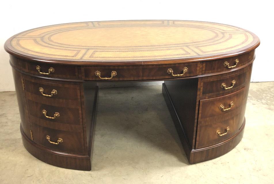 Maitland Smith oval partners leather top desk: With file drawers, drawers and cupboards 30"h x 70 1/2"w x 44 1/2"d Condition, some scratches and scuffs
