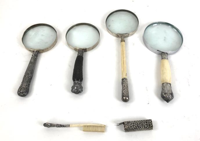 Group of 4 magnifying glasses: Together with bone toothbrush and sterling silver cover Two magnifying glasses have English silver mounts Largest 12"l x 4"w