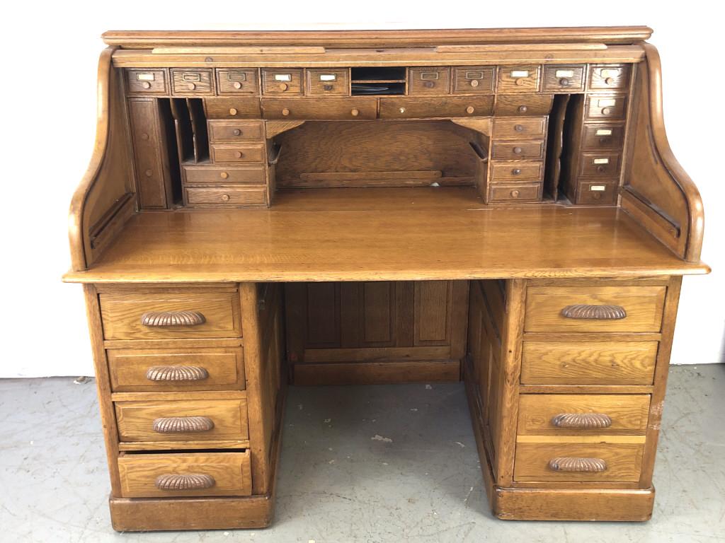 An Oak Roll Top Desk: 50"h x 59"w x 34"d Condition , center drawer runner missing, some wheels missing to base, one handle loose
