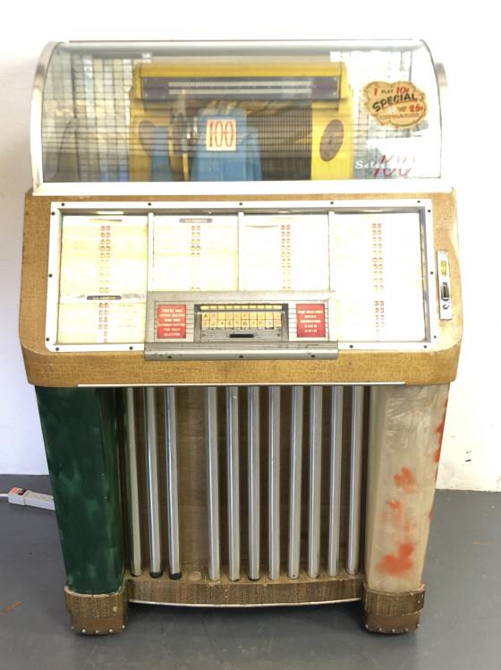 Seeberg Selectomatic Model M100C Juke Box: Seeberg Selectomatic Model M100C Juke Box. 54 1/4"h x 36"w x 26"d. Condition, mechanism picks up records, possibly needs new needle, humming from speaker, one metal bar missing from front , some loss 
